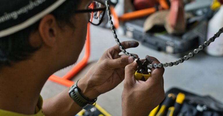 Mechaniker arbeitet in einer Werkstatt an einer Fahrradkette