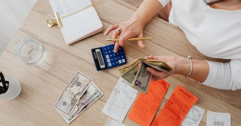 Taschenrechner, Kassenbons und Bargeld auf einem Schreibtisch von oben
