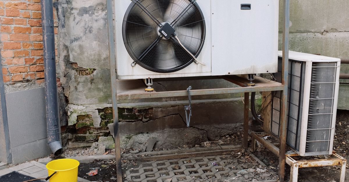 Außengerät einer Klimaanlage auf einem Metallpodest an einer Hauswand