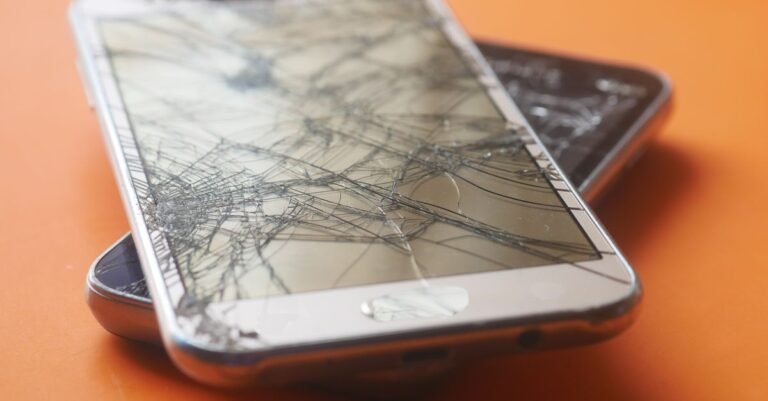 Zwei defekte Smartphone-Displays auf orangefarbenem Hintergrund