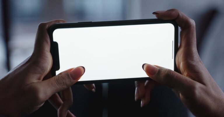 Hände halten ein Smartphone mit leerem Bildschirm